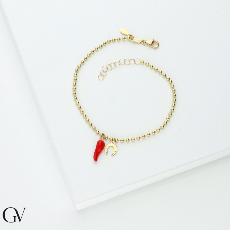 18K yellow gold bracelet with a red lucky horn and a horseshoe charm