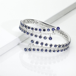 Bypass semi-rigid diamond and blue sapphire bracelet.
