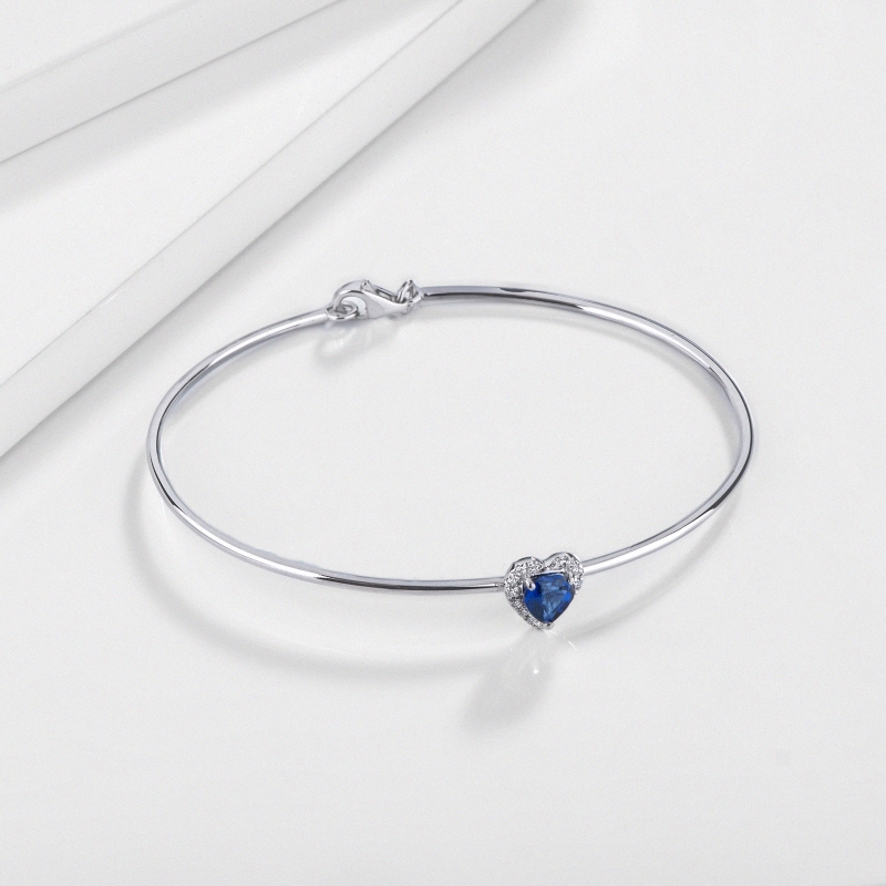 Thin bangle bracelet with diamonds and heart-shaped blue sapphire in 18kt white gold Thin bangle bracelet with diamonds and heart-shaped blue sapphire in 18kt white gold