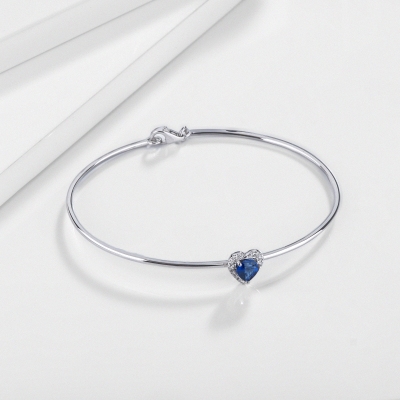 Thin bangle bracelet with diamonds and heart-shaped blue sapphire in 18kt white gold