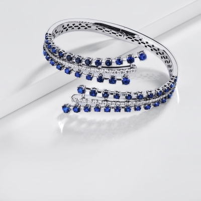 Bypass semi-rigid diamond and blue sapphire bracelet.