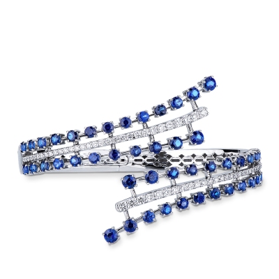 Bypass semi-rigid diamond and blue sapphire bracelet.
